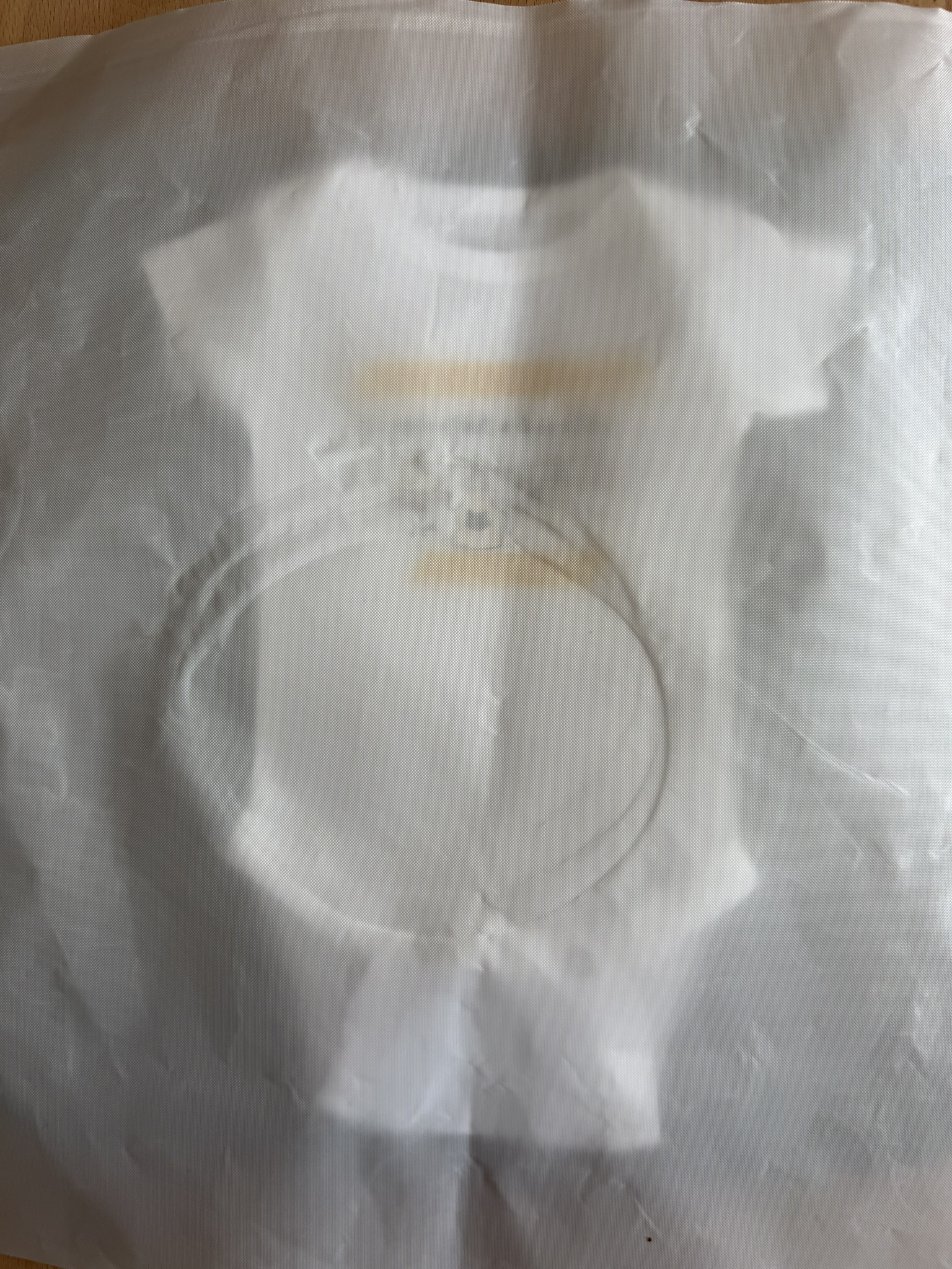 Teflon pressing sheet on top of a preemie bodysuit with a DTF design ready to the pressed.