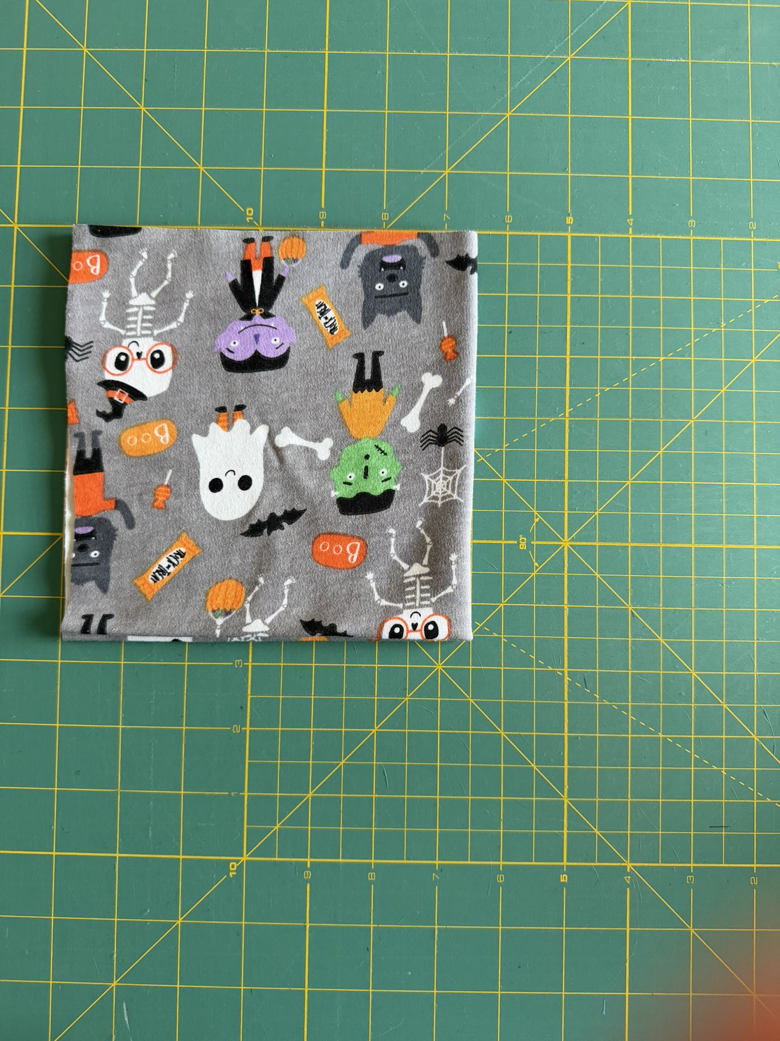 Halloween knit fabric double folded to prepare for a preemie hat pattern.