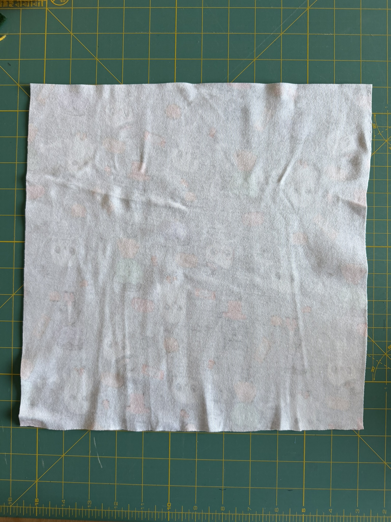 Fabric laid out on a green cutting mat.