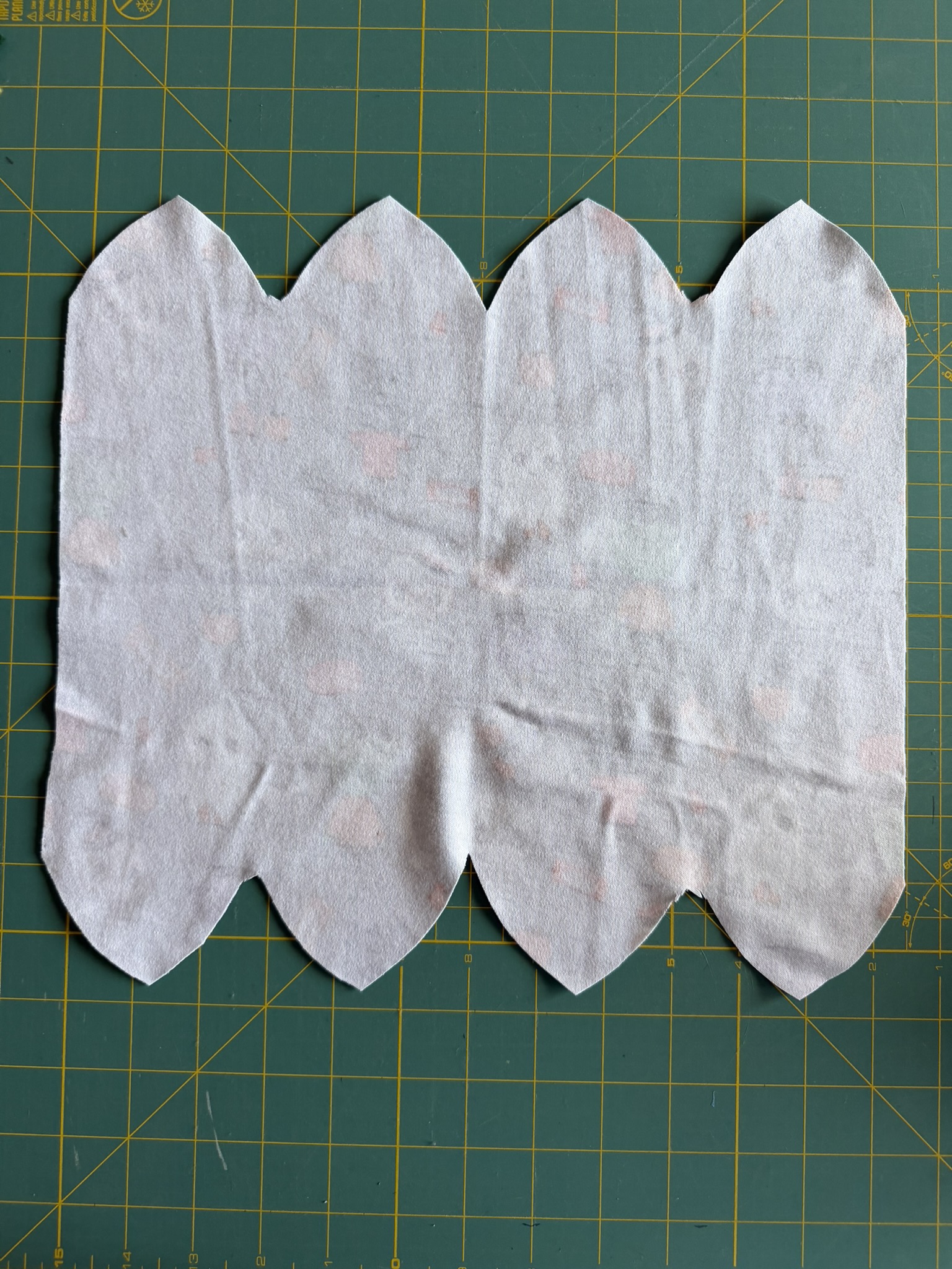 Knit fabric that has been cut to make a preemie hat unfolded to display all of the cuts.