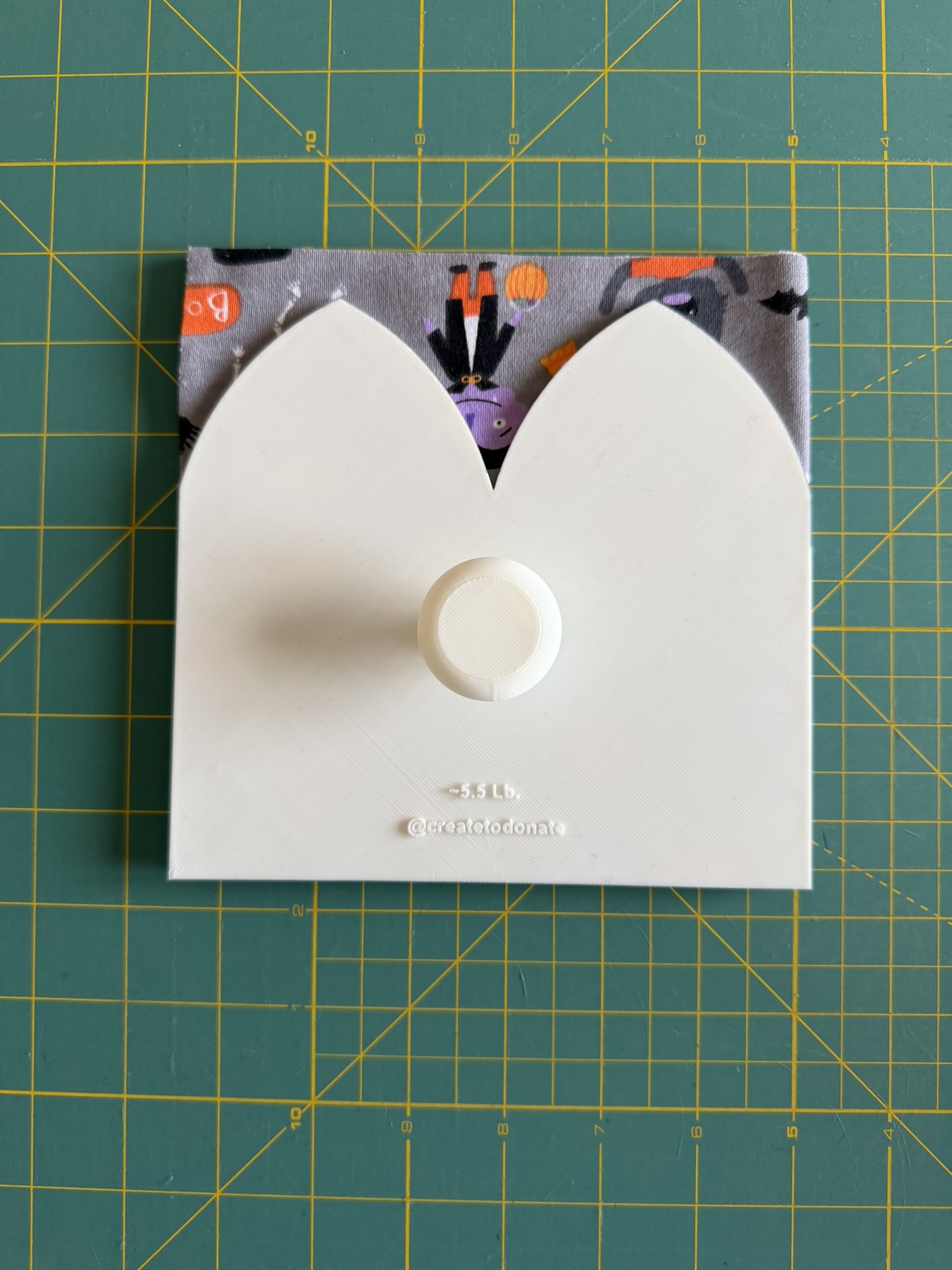 3D printed preemie hat pattern placed on top of gray knit fabric.