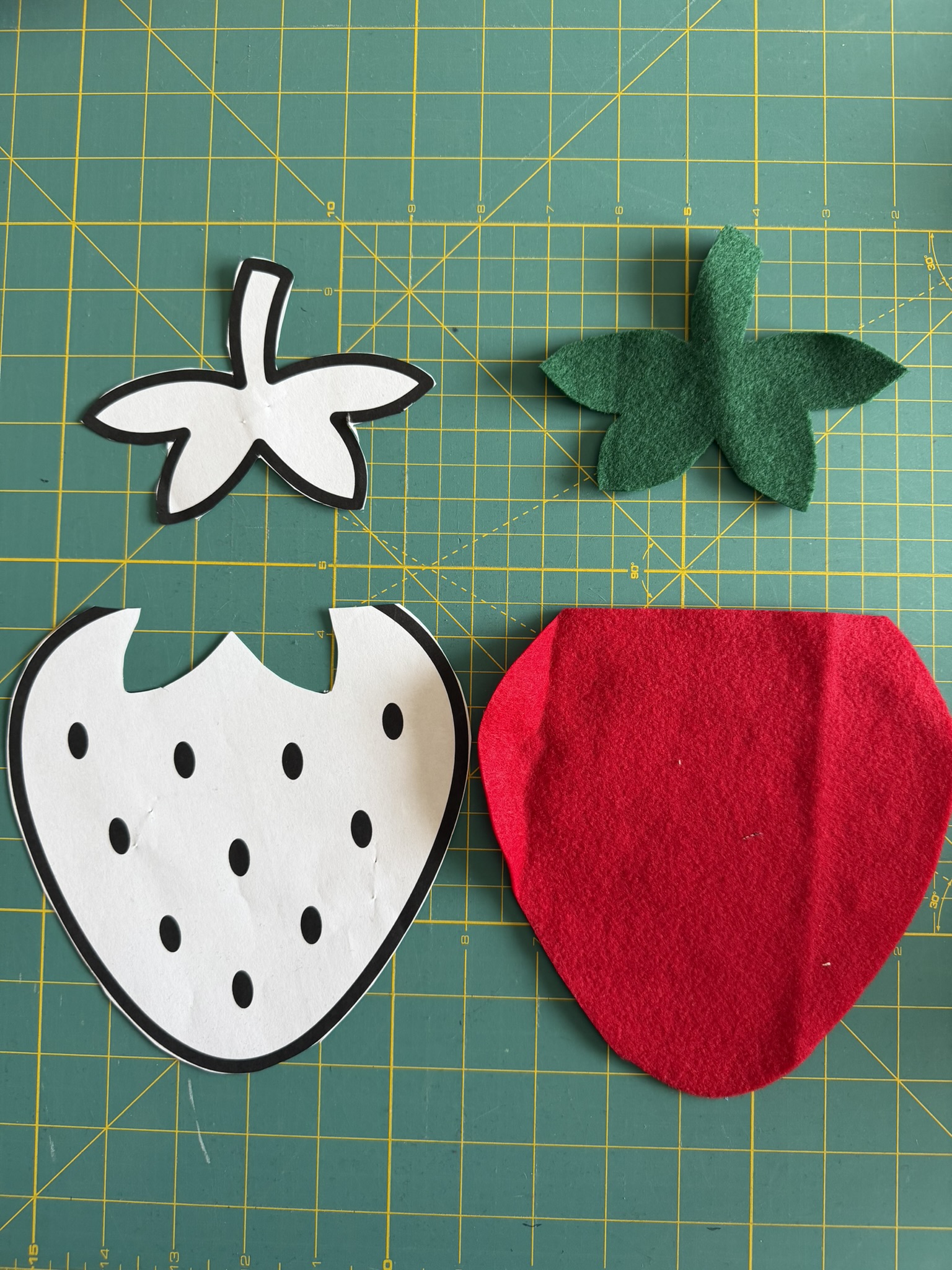 Felt cut out of a strawberry next to the template used to cut it out.