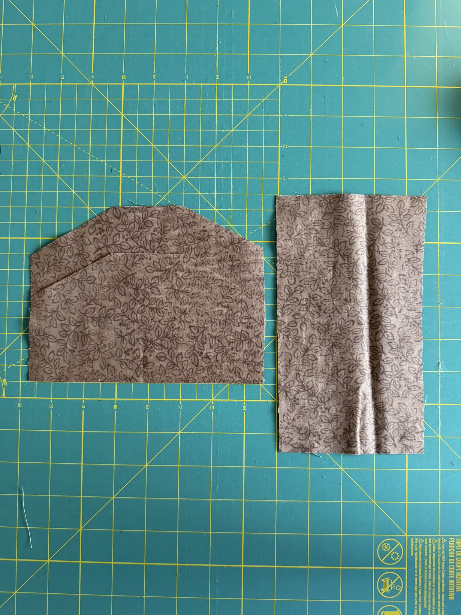 Fabric pieces for the top of the hanging kitchen towel laid out on a green cutting mat.