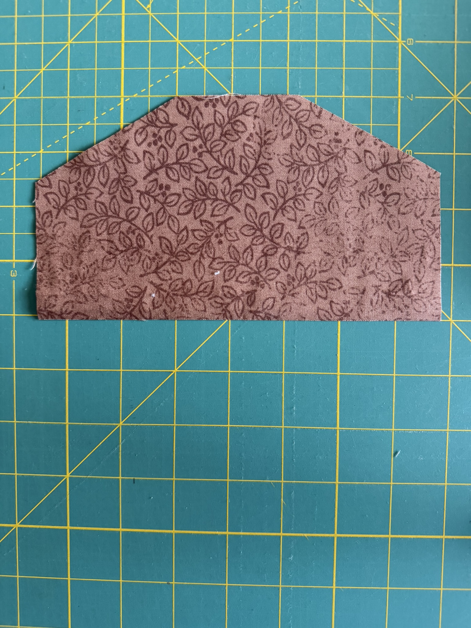 brown fabric laid out on a green cutting mat.