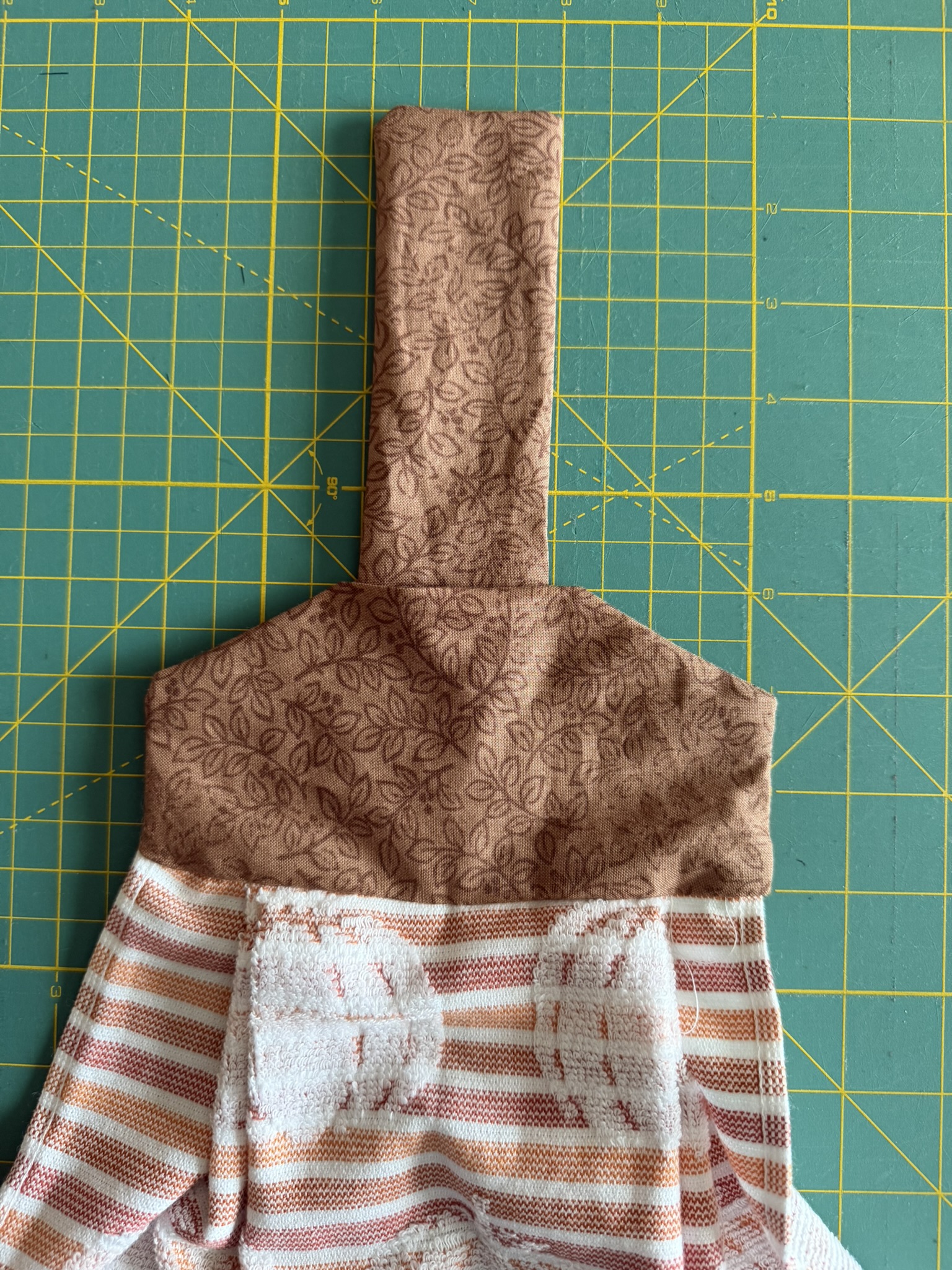 DIY tutorial for a hanging towel with the fabric rectangle inserted into the raw edge to make the hanging part of the towel.